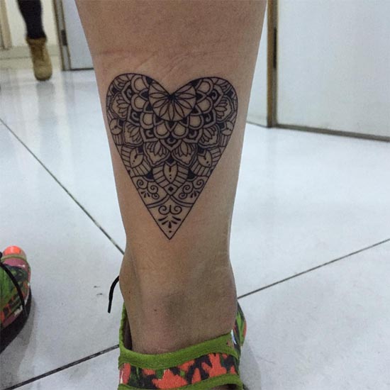 heart shaped mandala tattoo idea line work woman back ankle