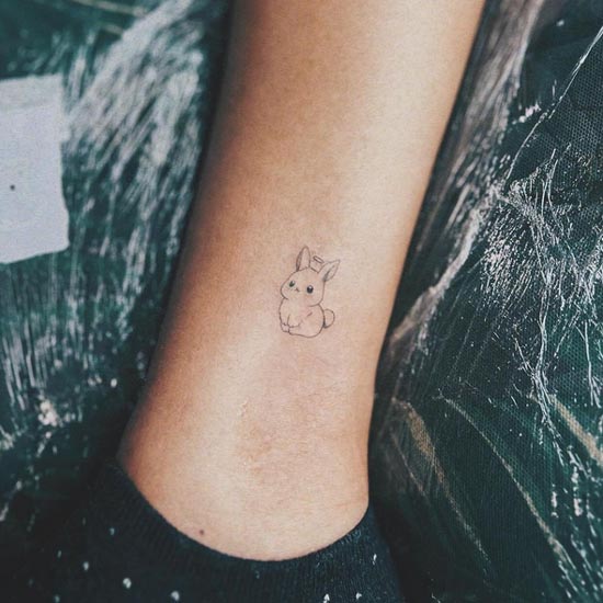 small rabbit fine line tattoo woman ankle