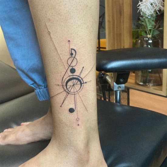 treble clef geometric linework tattoo female ankle vertical