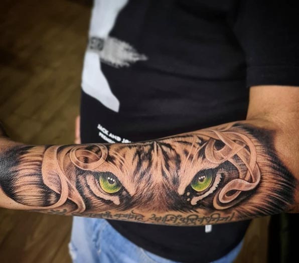 tiger eyes tattoo lower half arm sleeve man