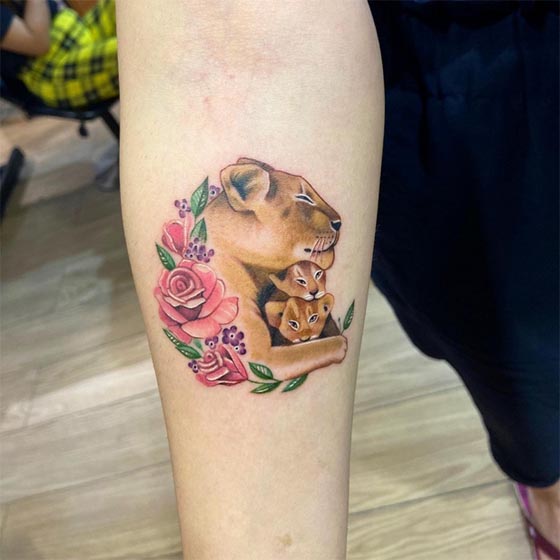 lioness with her two cubs rose flower tattoo color woman arm inner upper forearm