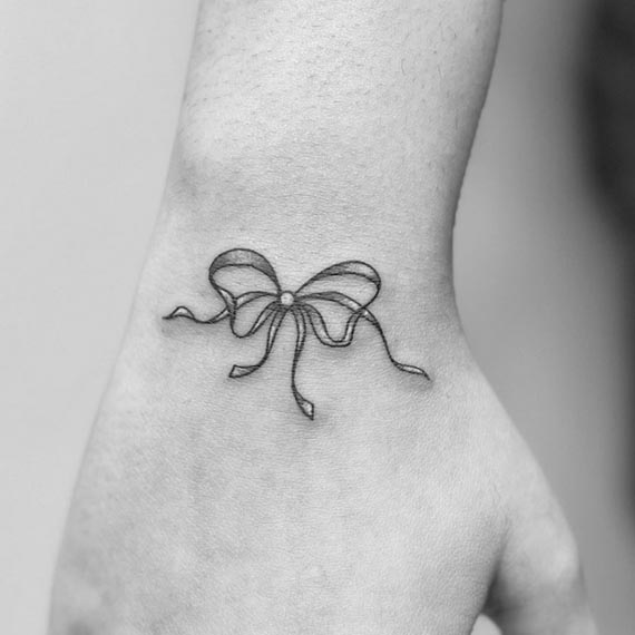 minimalist ribbon linework cute tattoo female lower outer arm wrist 1