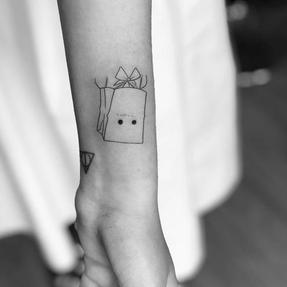 paper bag cute tattoo fine line drawing female arm lower side forearm