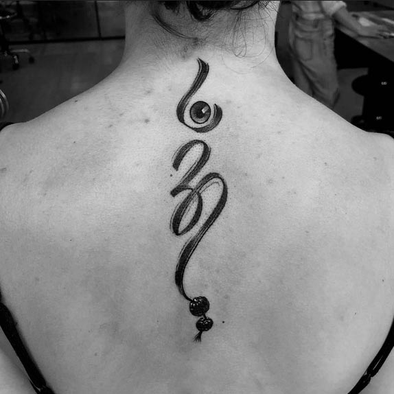 om tattoo design idea female back black and grey