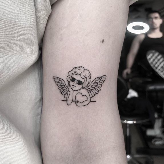 baby cupid angel simple tattoo design female front lower bicep