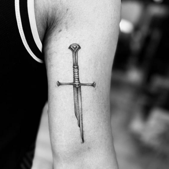 broken sword viking simple tattoo black and grey male front bicep