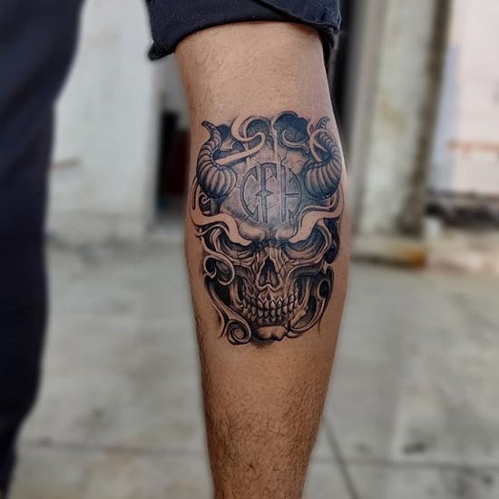 skull with horns mask tattoo design male upper calf