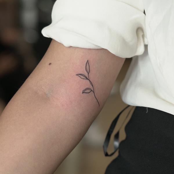 small leaves tattoo design fine line girl inner elbow