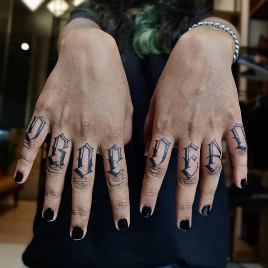 word drop dead tattoo lettering female finger