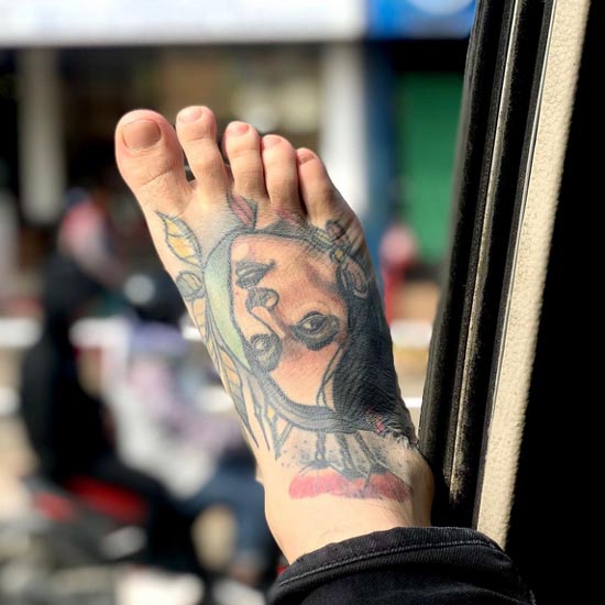 portrait tattoo on guy foot