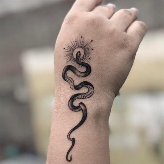 minimalist snake with sun simple tattoo design girl hand wrist