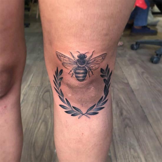 bee leaves blackwork tattoo woman over knee