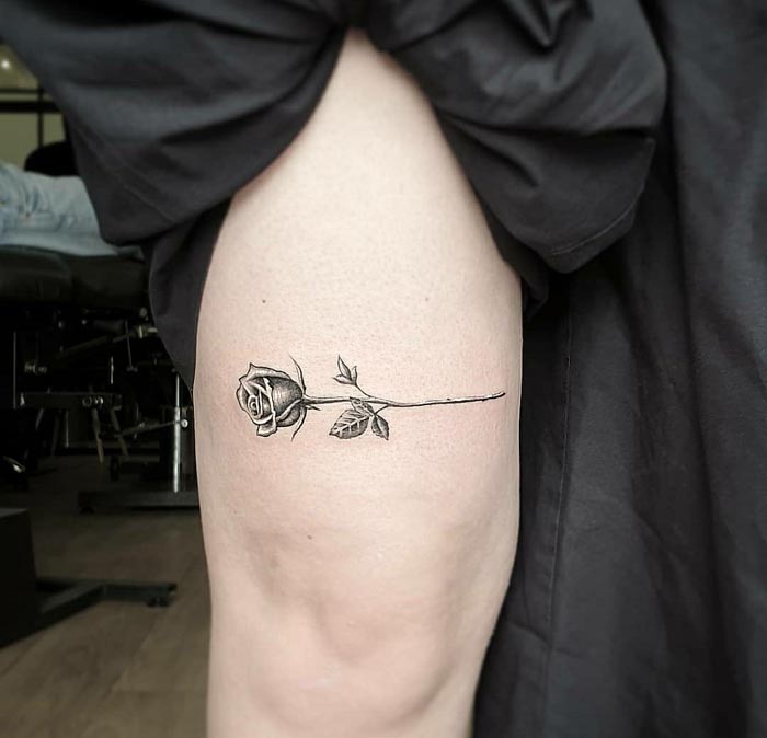 black small rose simple tattoo design idea lady upper leg above knee