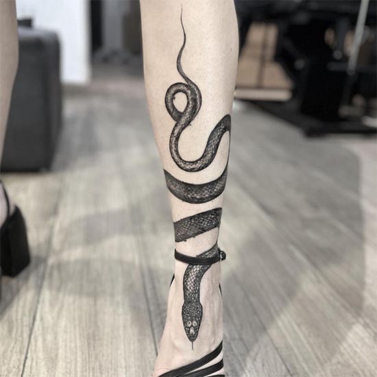 snake wrapped around lower leg tattoo female black and grey