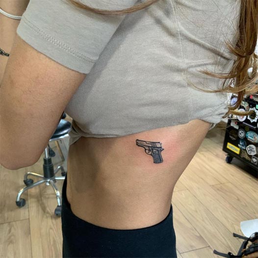 gun revolver small tiny tattoo minimal female rib