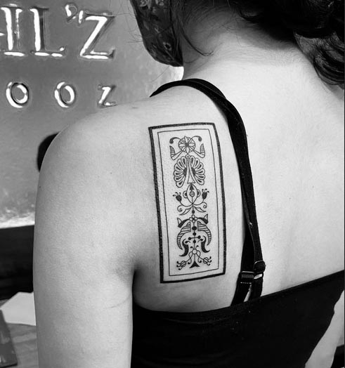 intricate patterns symbols in panel woman back shoulder