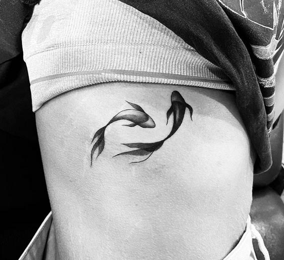 2 fishes yin yang tattoo design woman side rib black and grey