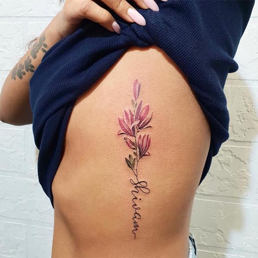 shivam name on stem of colored flowers cute tattoo girl side