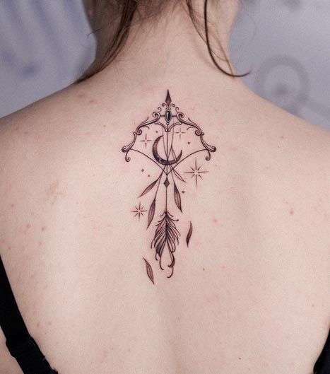 delicate bow arrow crescent moon tattoo fine line woman spine