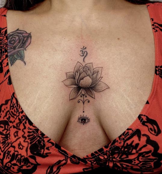 lotus flower om evil eye tattoo female sternum