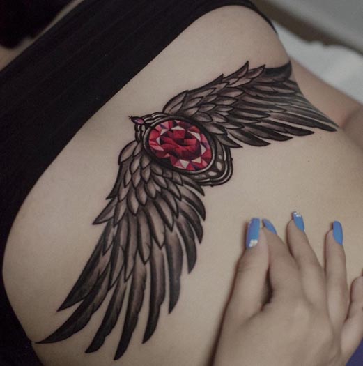 gemstone with wings realistic tattoo idea female stomach below breast