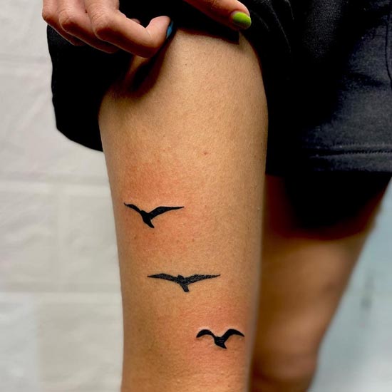 3 flying birds tattoo blackwork girl lower thigh