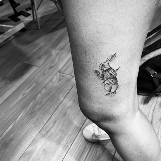 rabbit small tattoo minimalist female side lower thigh