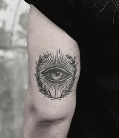 eye surrounded by leaves tattoo design woman tricep