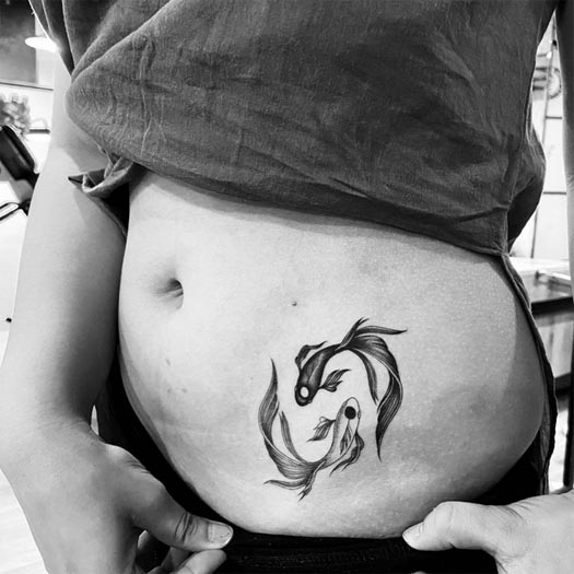 2 small fishes yin yang tattoo design female side lower waist