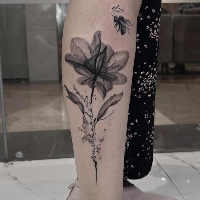 leg athena flower with honeybee tattoo