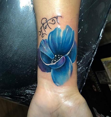 blue color poppy flower tattoo design color female inner wrist