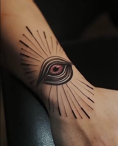 freehand big evil eye with lines around it tattoo male wrist hand