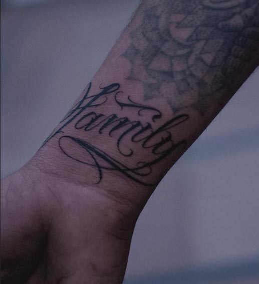 word family calligraphy script tattoo male wrist